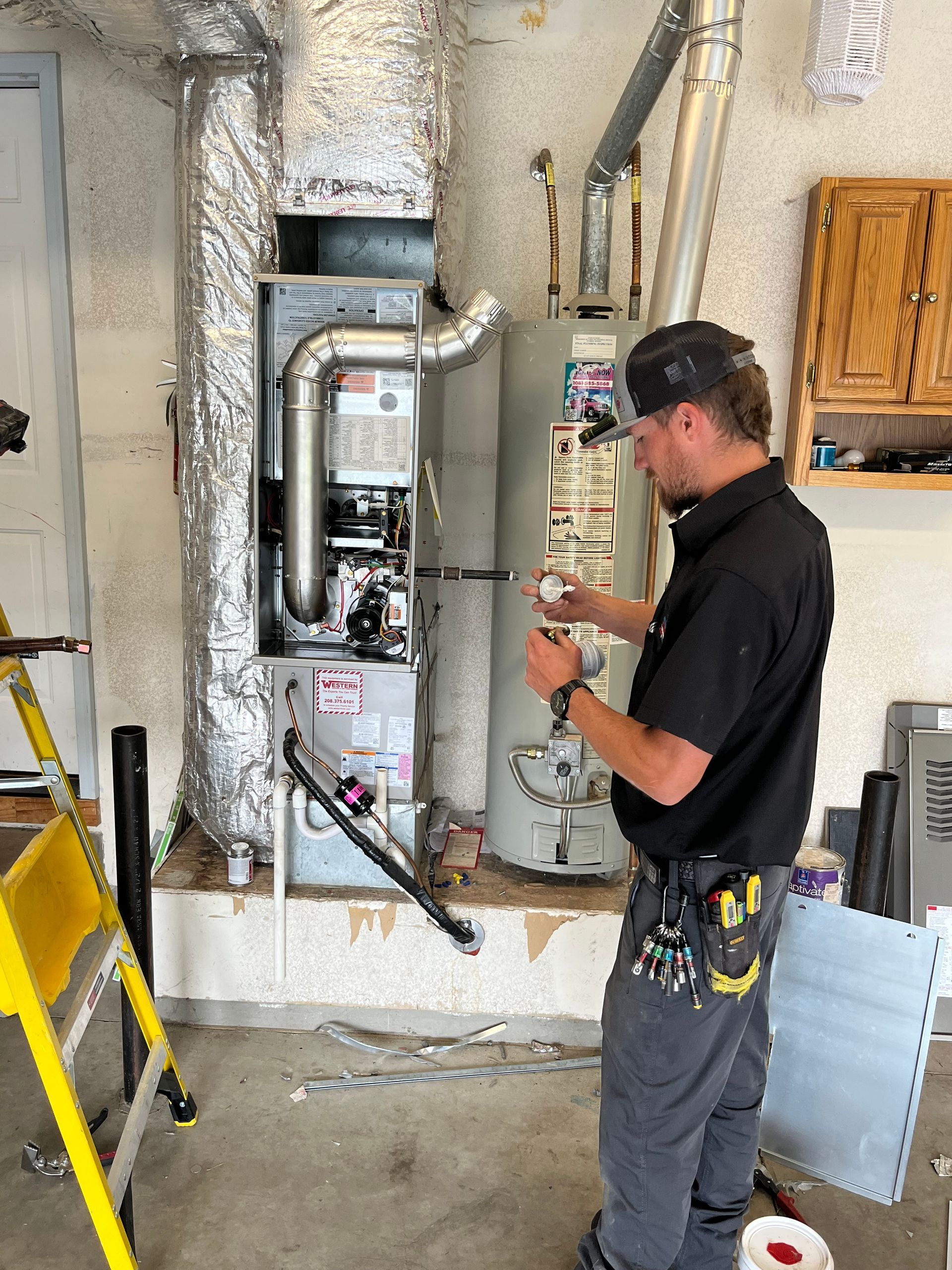 A man is working on a heating system in a garage.