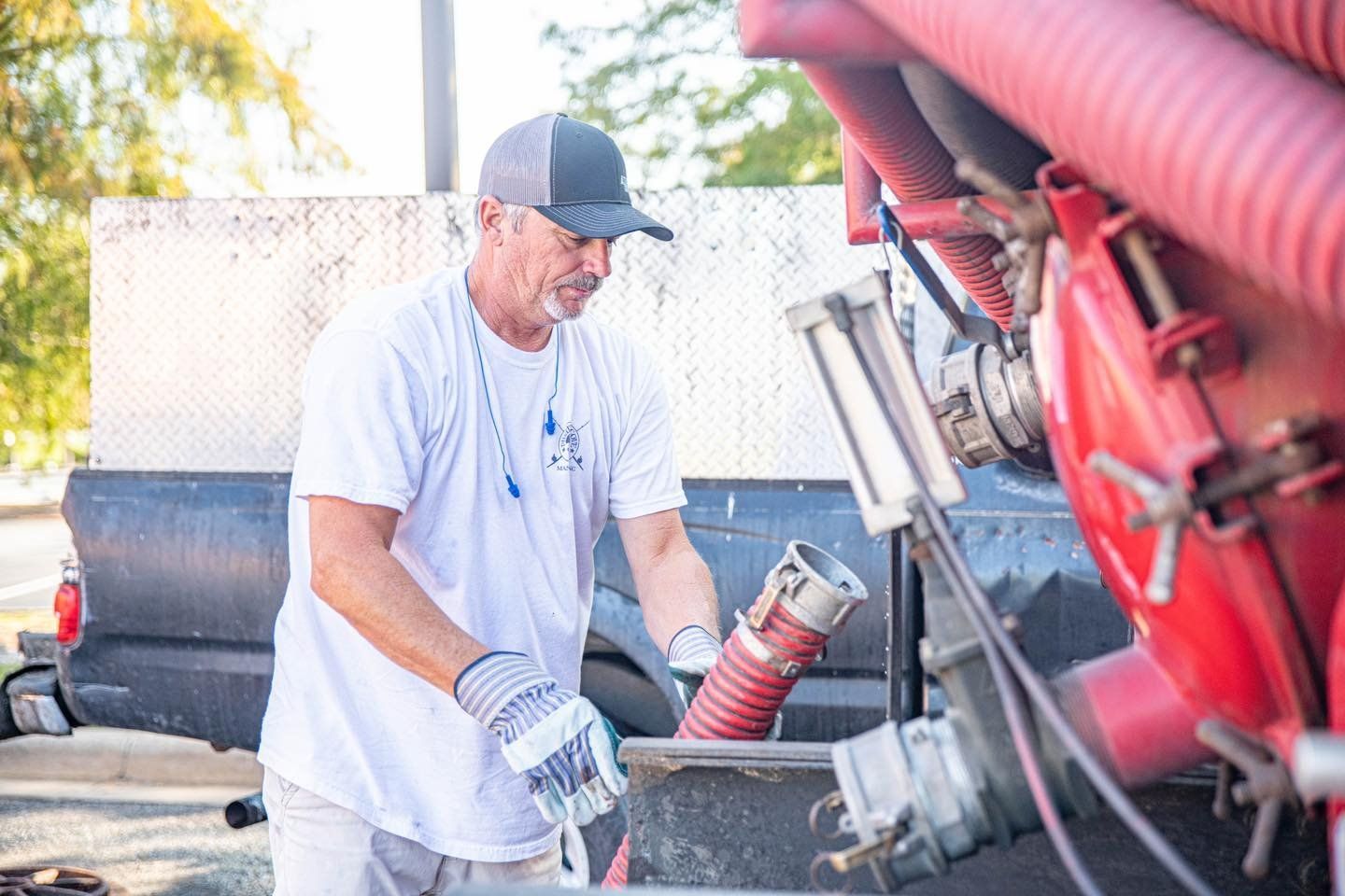 A man is working on a vacuum truck.
