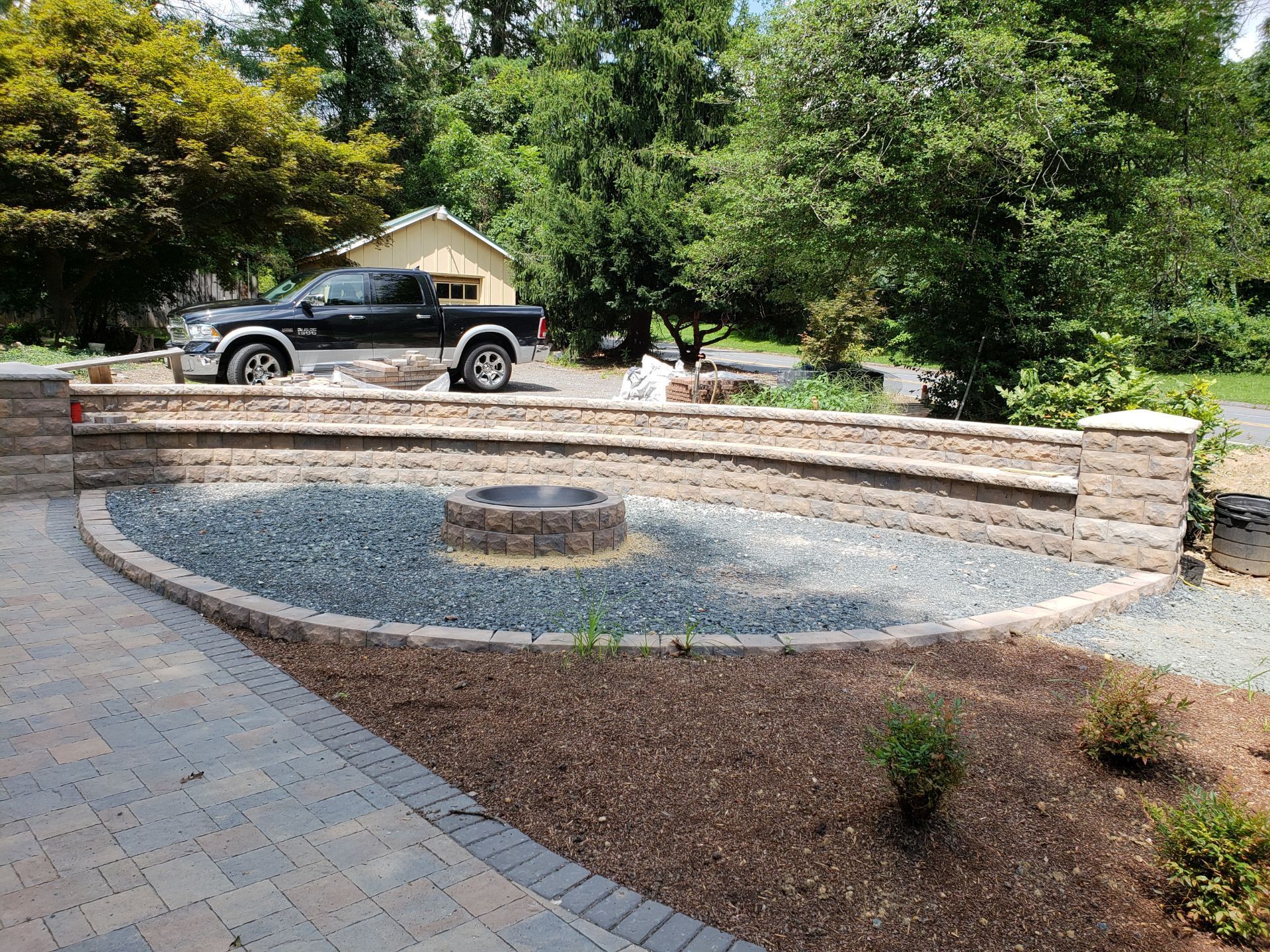 A black truck is parked in front of a fire pit.