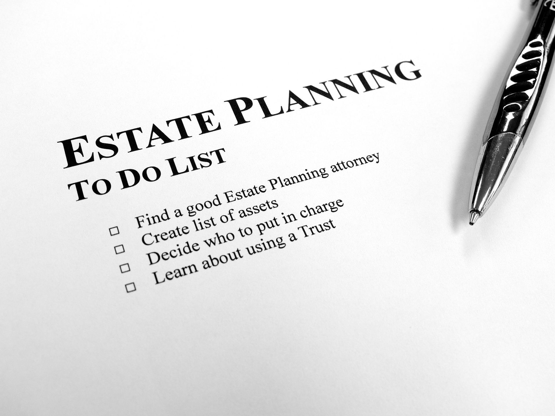 An estate-planning to-do list on a desk with a black pen.