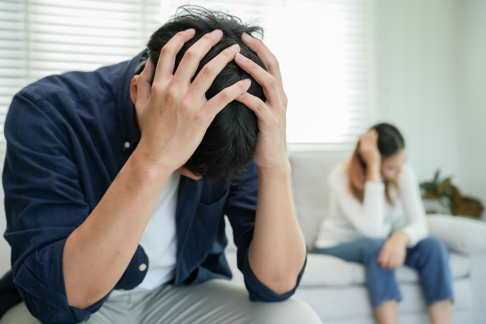 Toy house next to a gavel, with a person in a suit writing in the background.