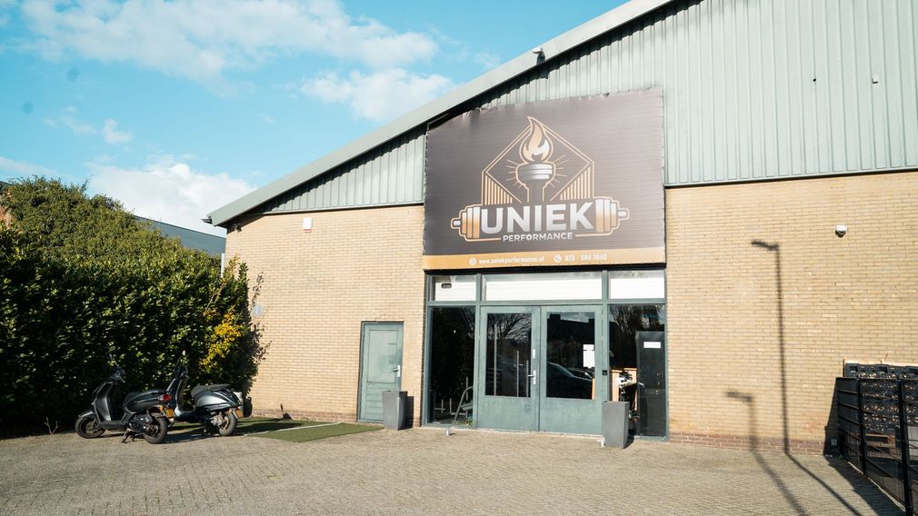 Een sportschool met veel fitnessapparatuur en led-verlichting.