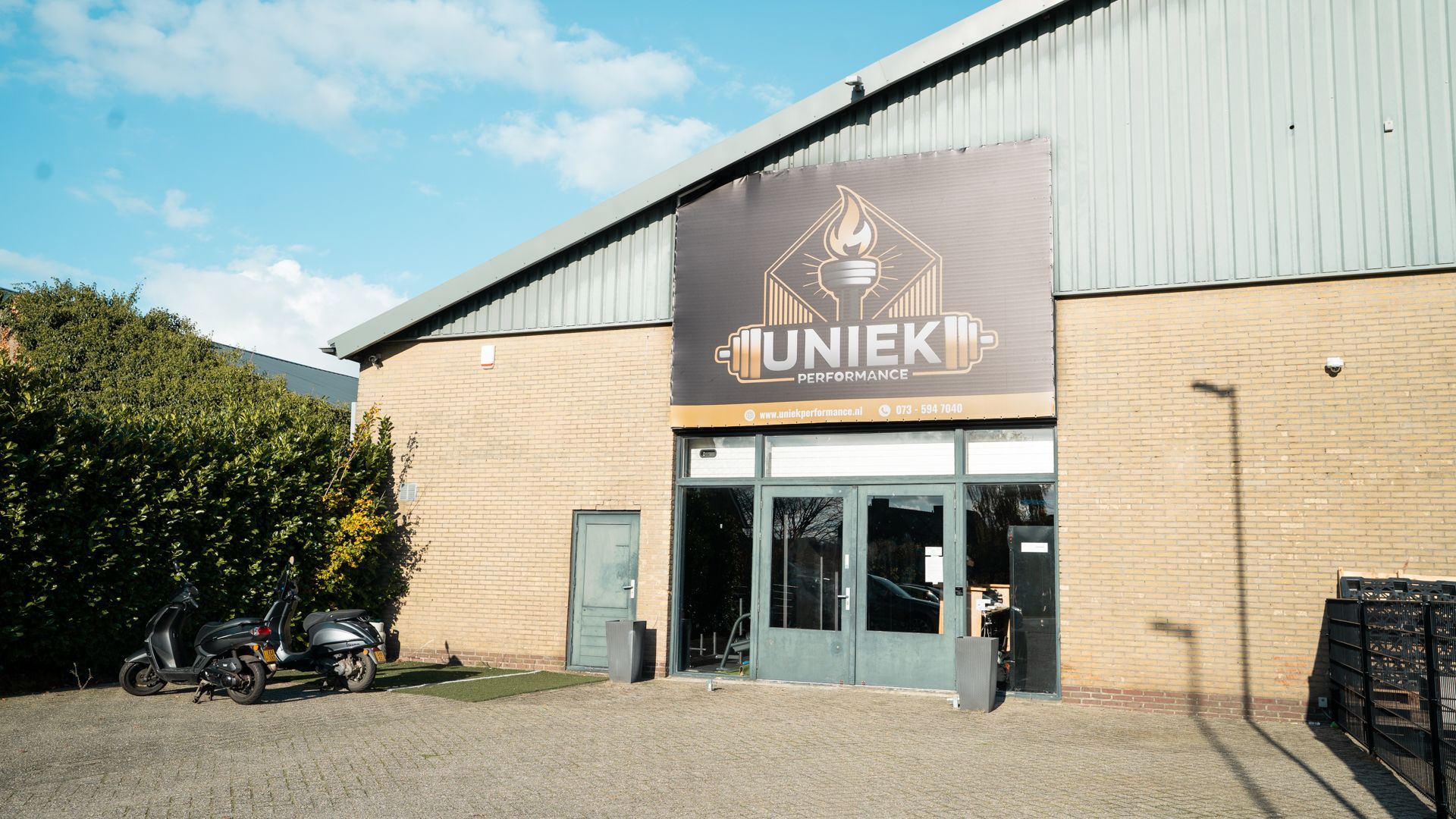 Een sportschool met veel fitnessapparatuur en led-verlichting.