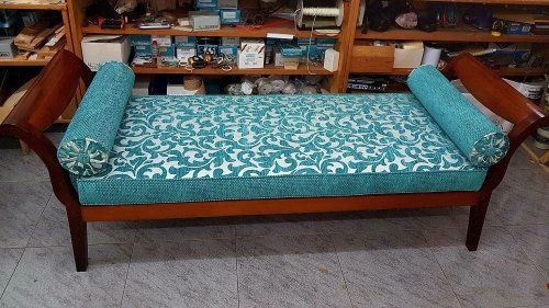 Un divano di legno rivestito in una stoffa di color azzurro