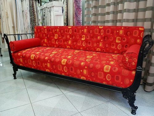 Un divano di legno rivestito in una stoffa di color rosso