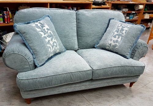un divano di color azzurro con dei cuscini