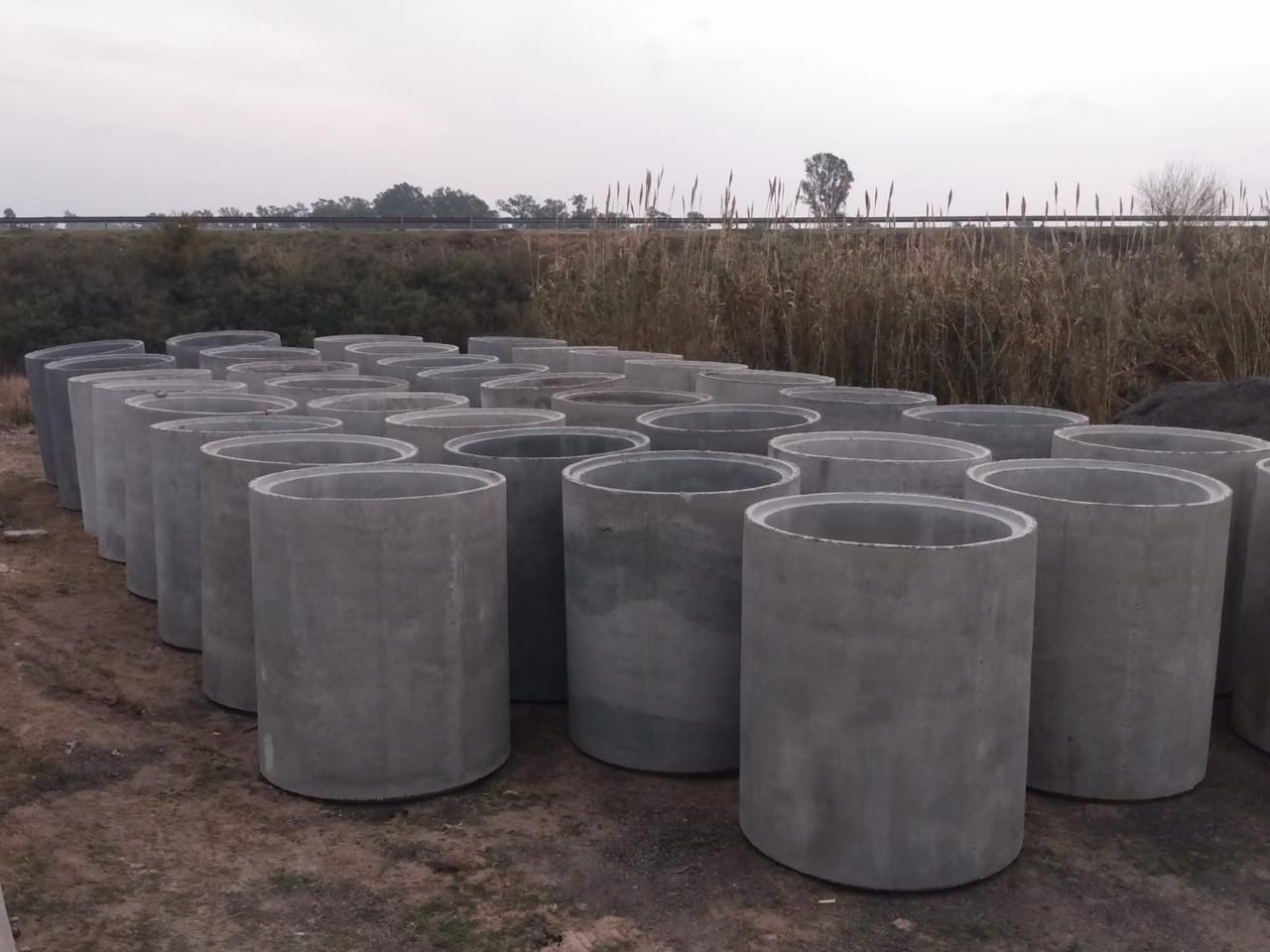 Tubos cilíndricos de hormigón dispuestos al aire libre en un campo.