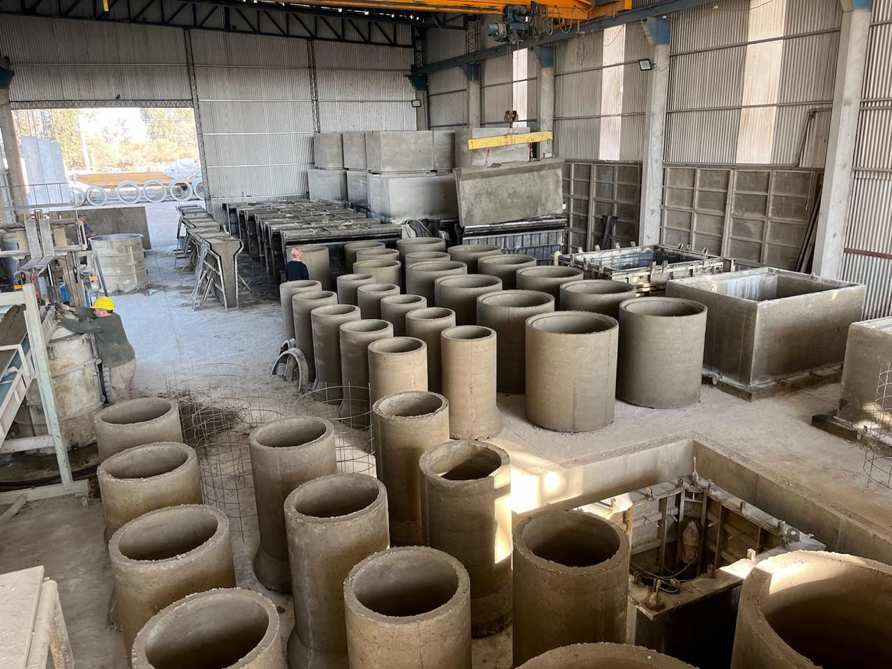 Cilindros de hormigón y formas rectangulares apiladas en el interior de una fábrica.