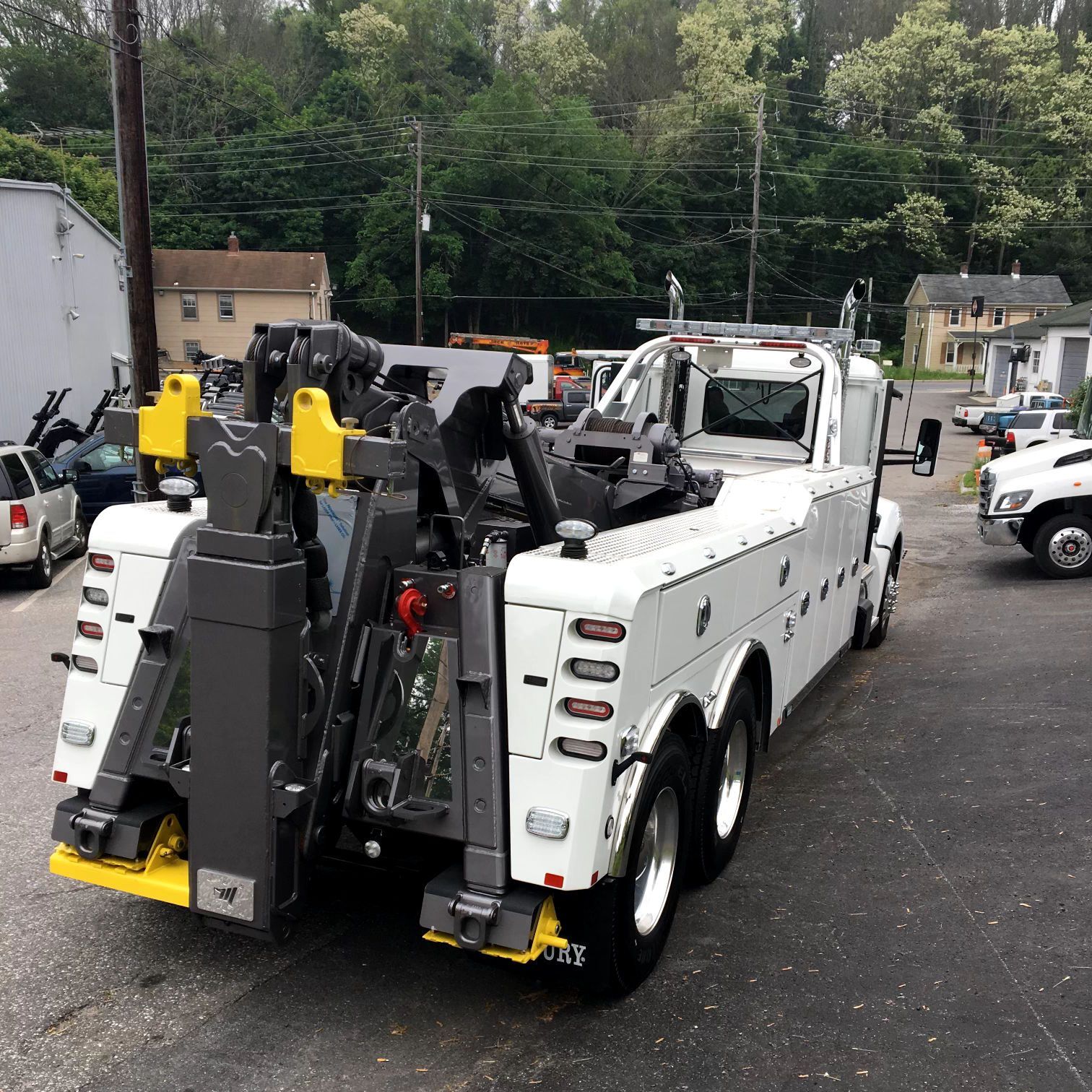 A white tow truck is parked in a parking lot