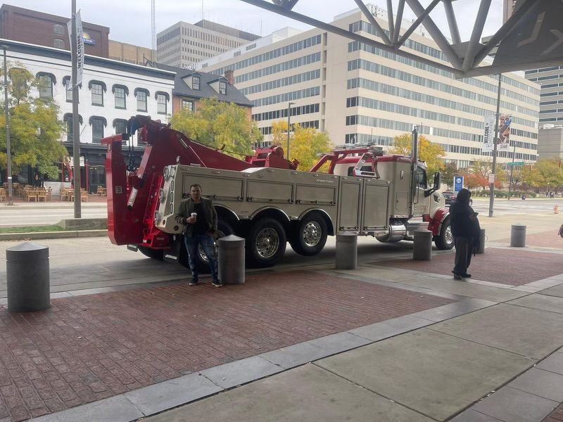 A red tow truck is parked on the side of the road