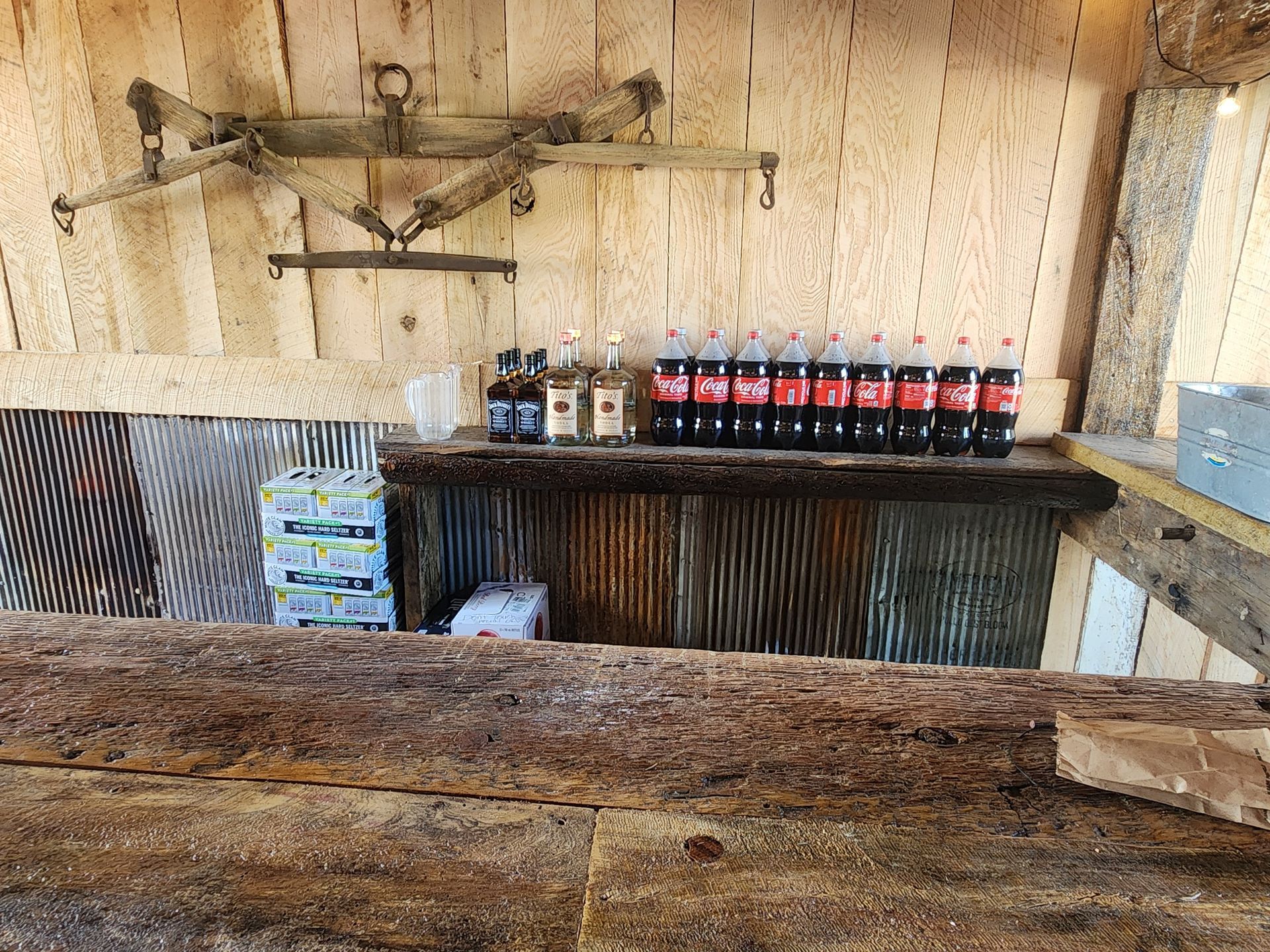 A wooden shelf with bottles of soda on it.