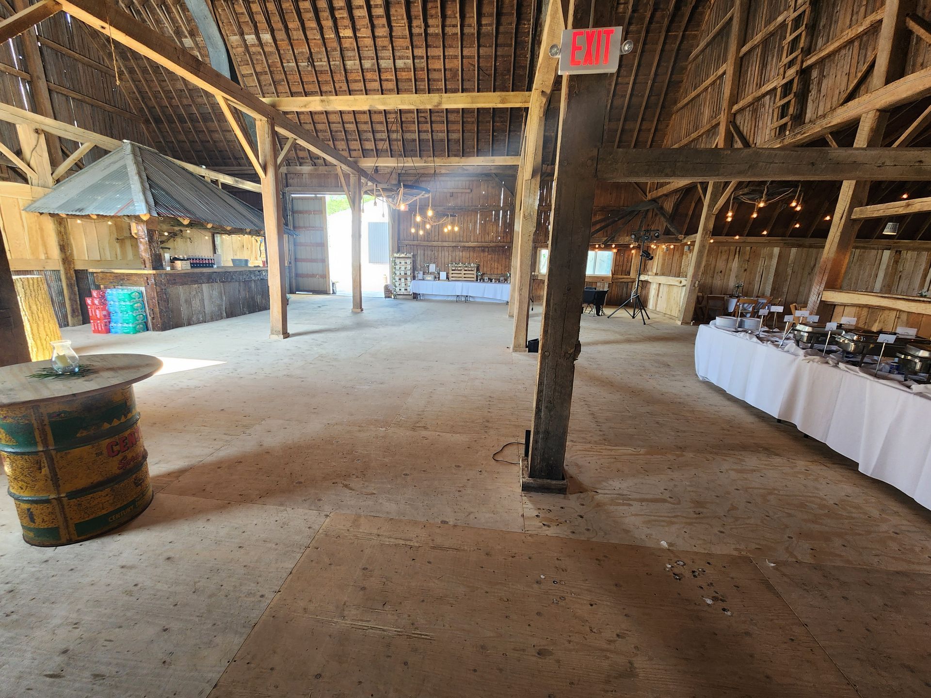 An empty barn with tables and a sign that says exit