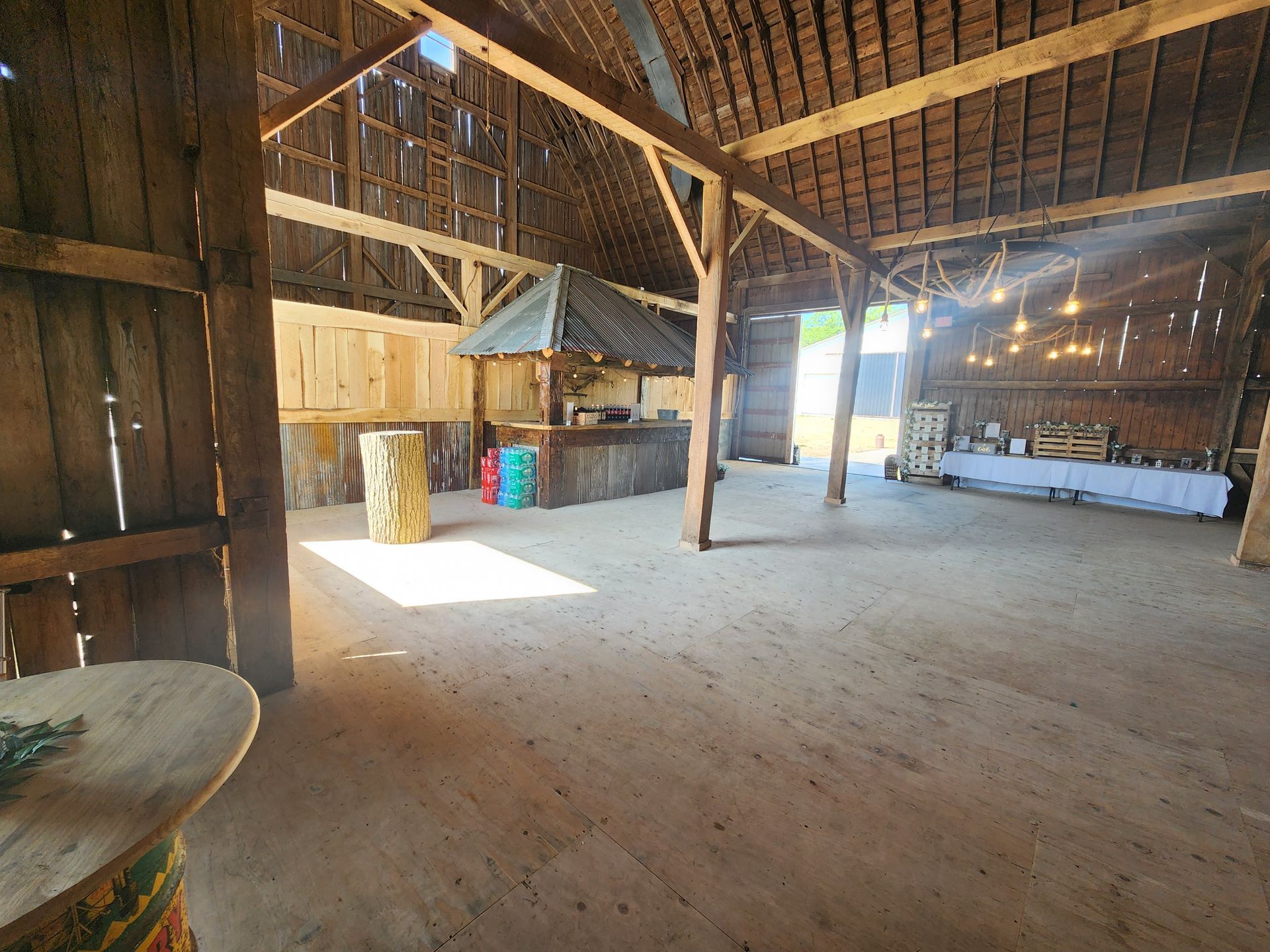 A large empty barn with a table in the middle of it.