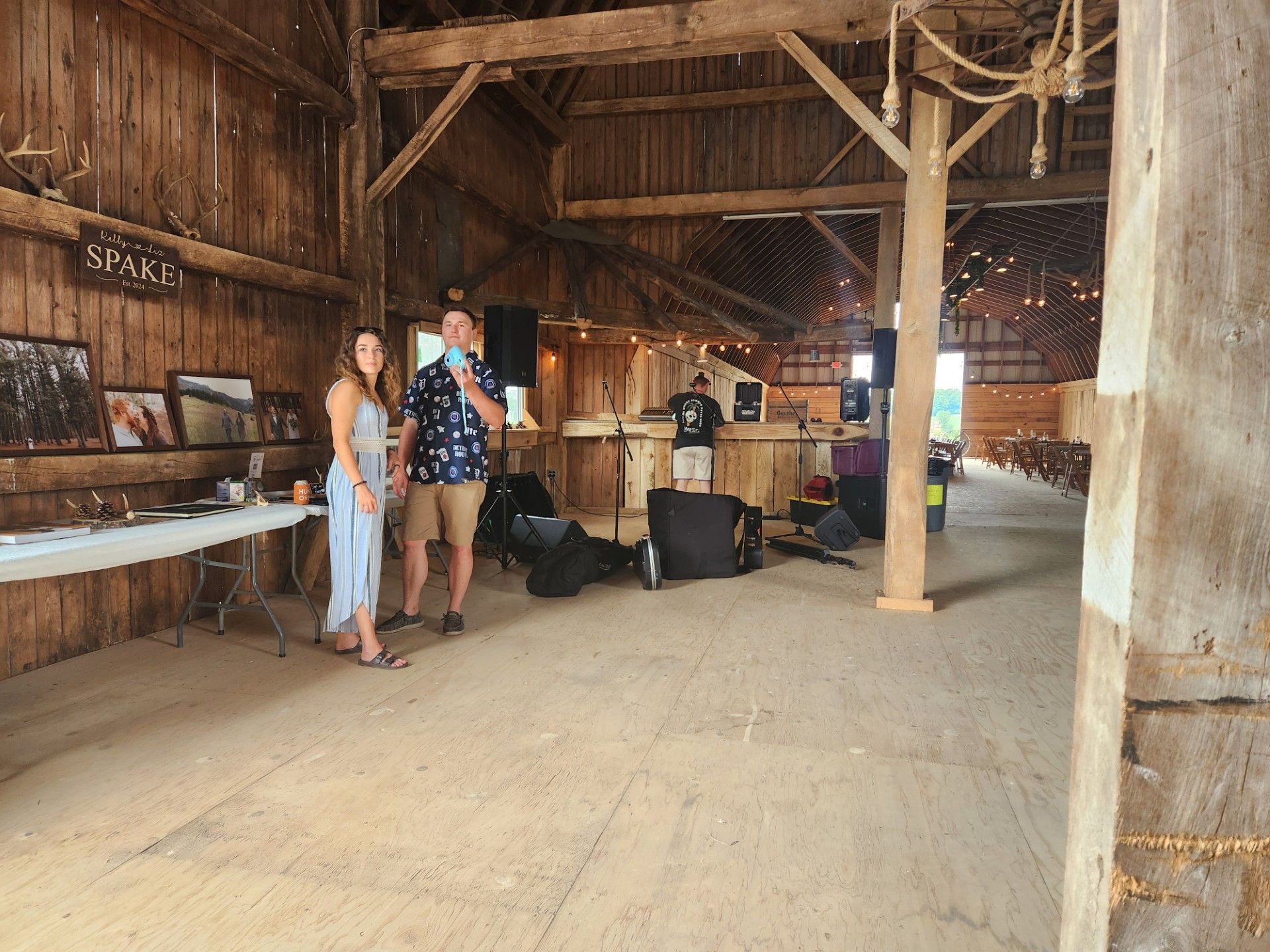 A man and a woman are standing in an empty barn.