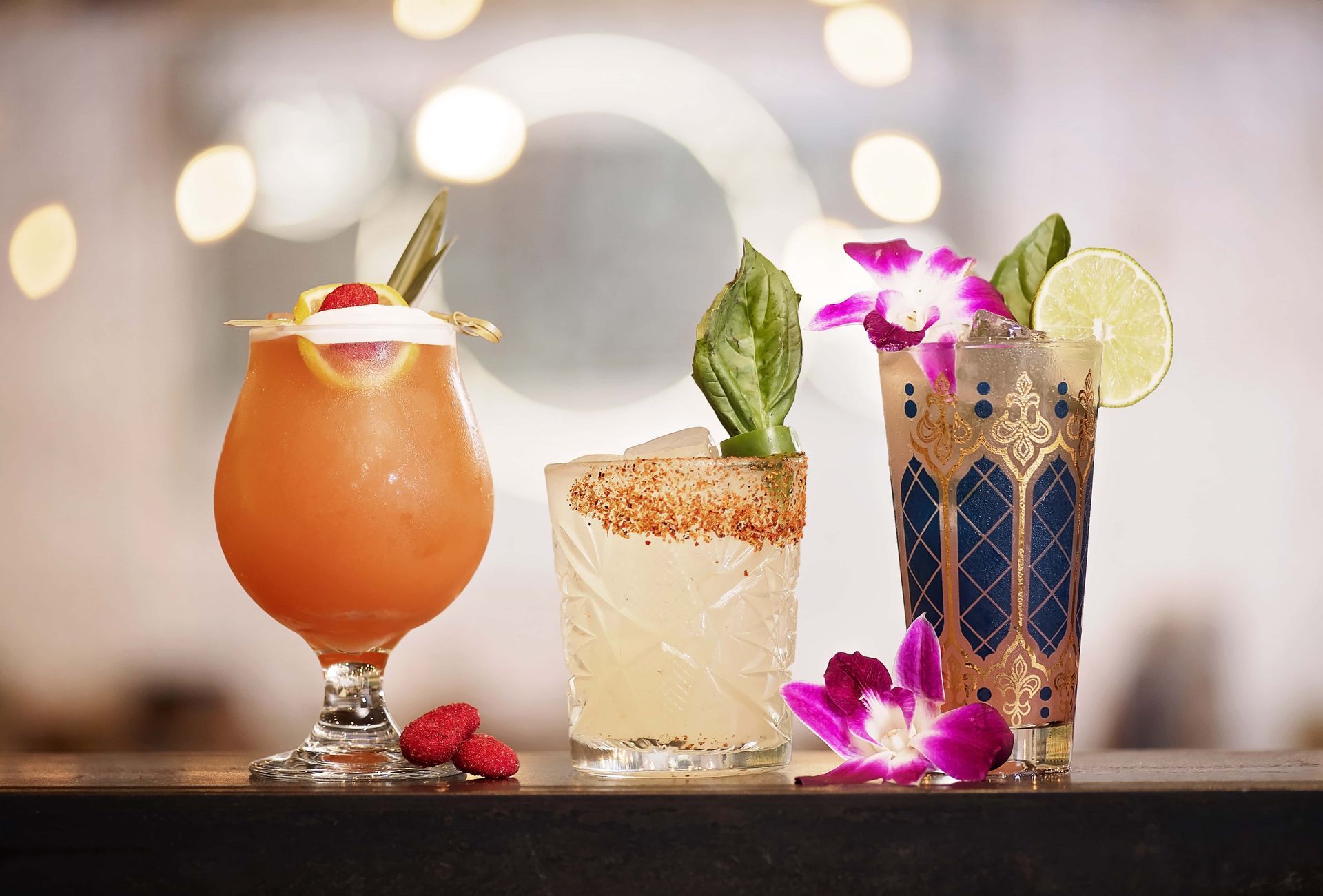 Three different types of drinks are sitting on a bar.