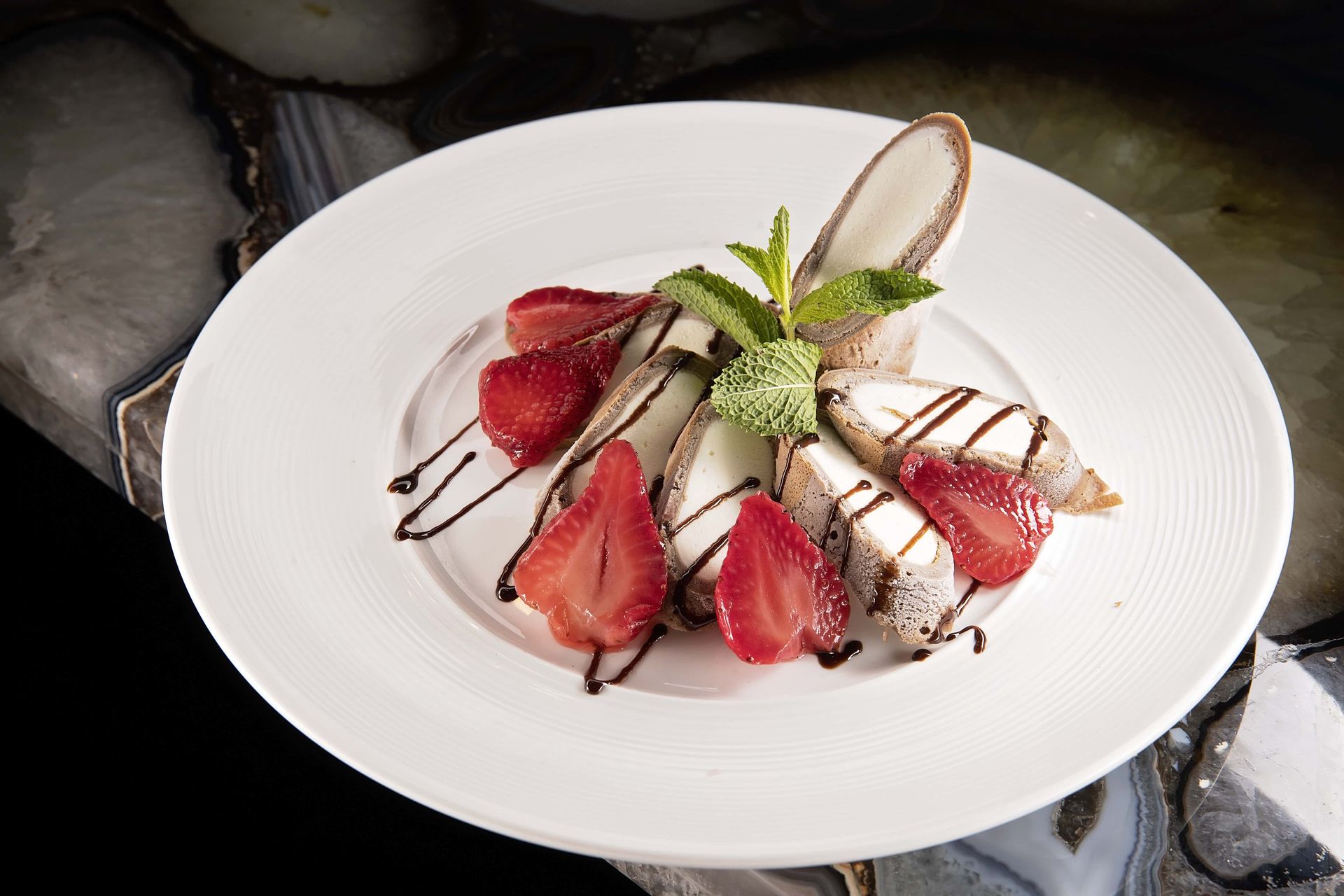 A white plate topped with strawberries and chocolate sauce.