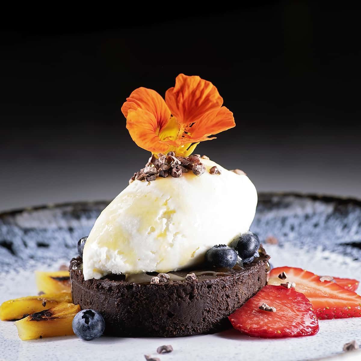 A chocolate dessert with ice cream and strawberries on a plate