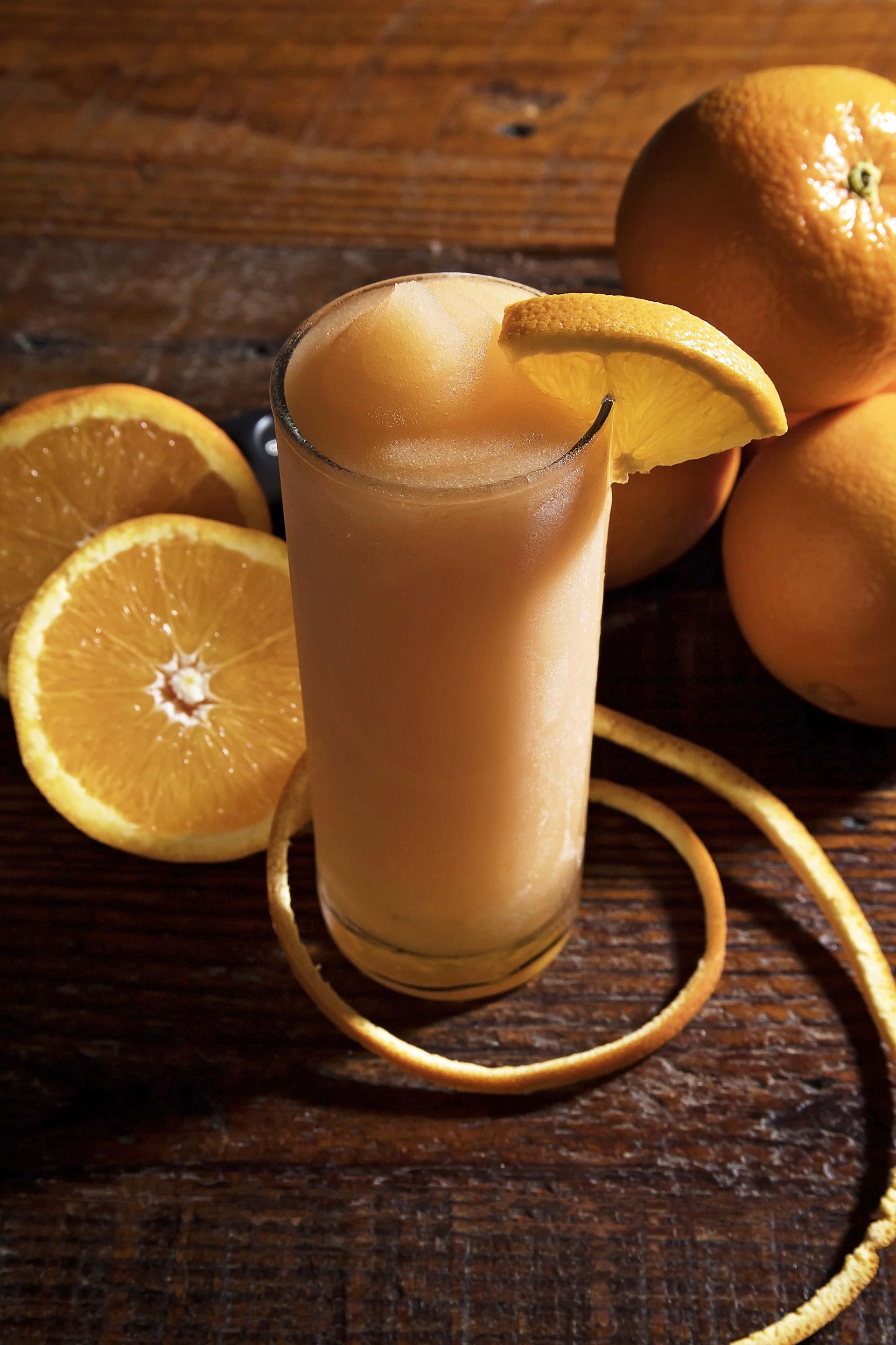 A glass of orange juice with a slice of orange on top