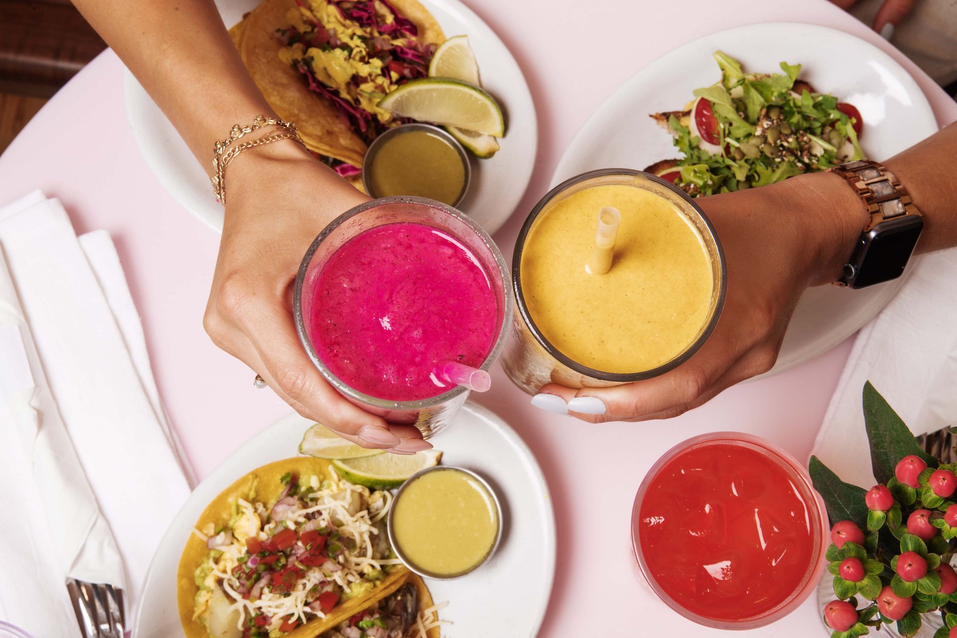 A group of people are sitting at a table with plates of food and drinks.