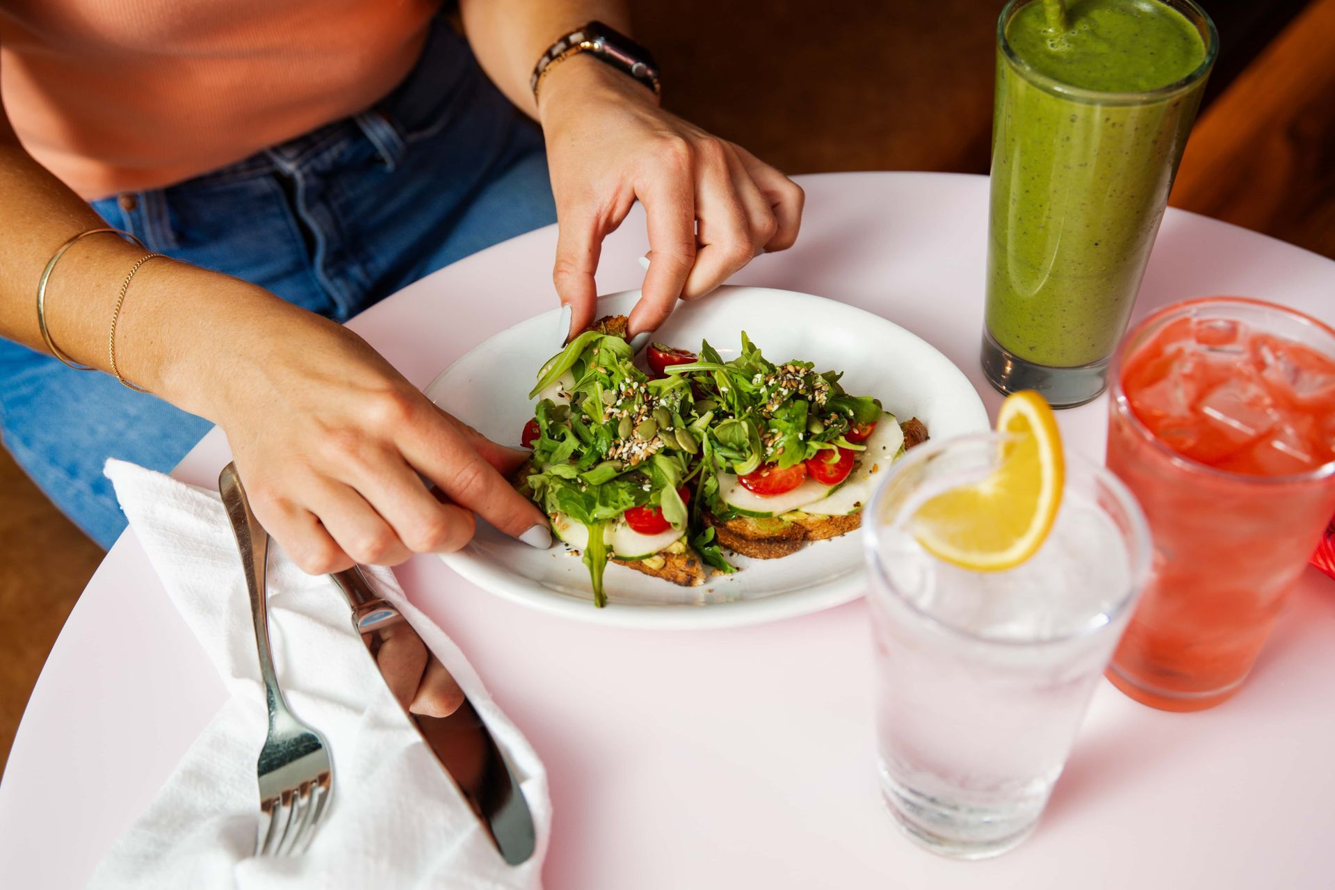 A woman is sitting at a table eating a plate of food.