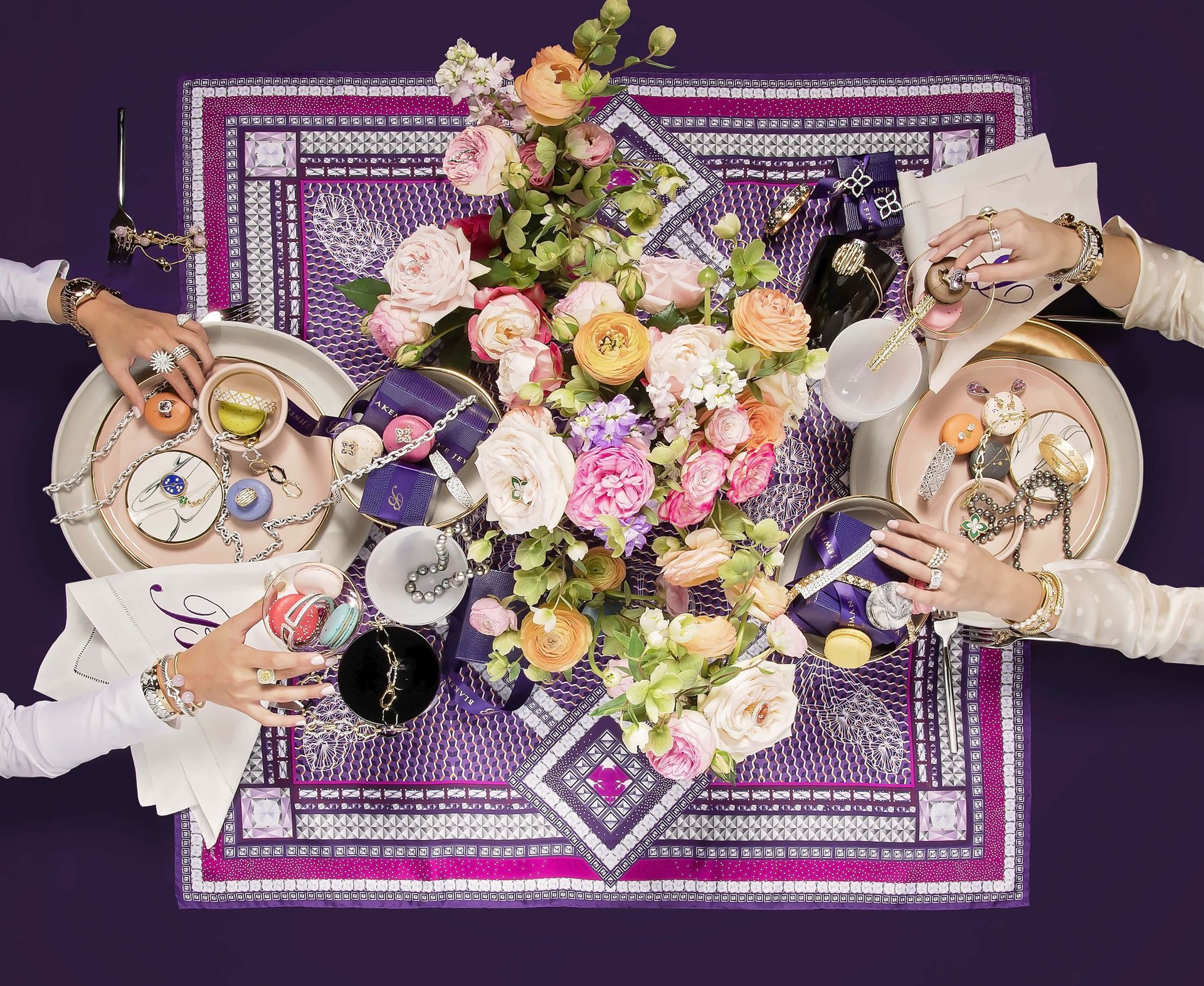 A group of people are sitting at a table with plates and flowers on it.