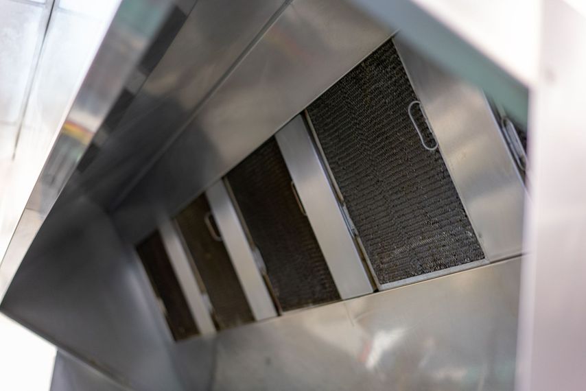 A close up of a stainless steel exhaust hood in a kitchen.