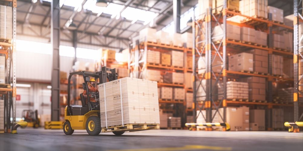 A forklift is carrying a pallet of boxes in a warehouse.