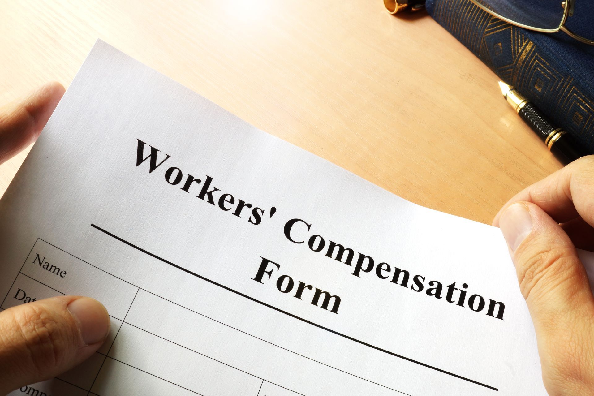 Workers Comp report with hands filling out the form