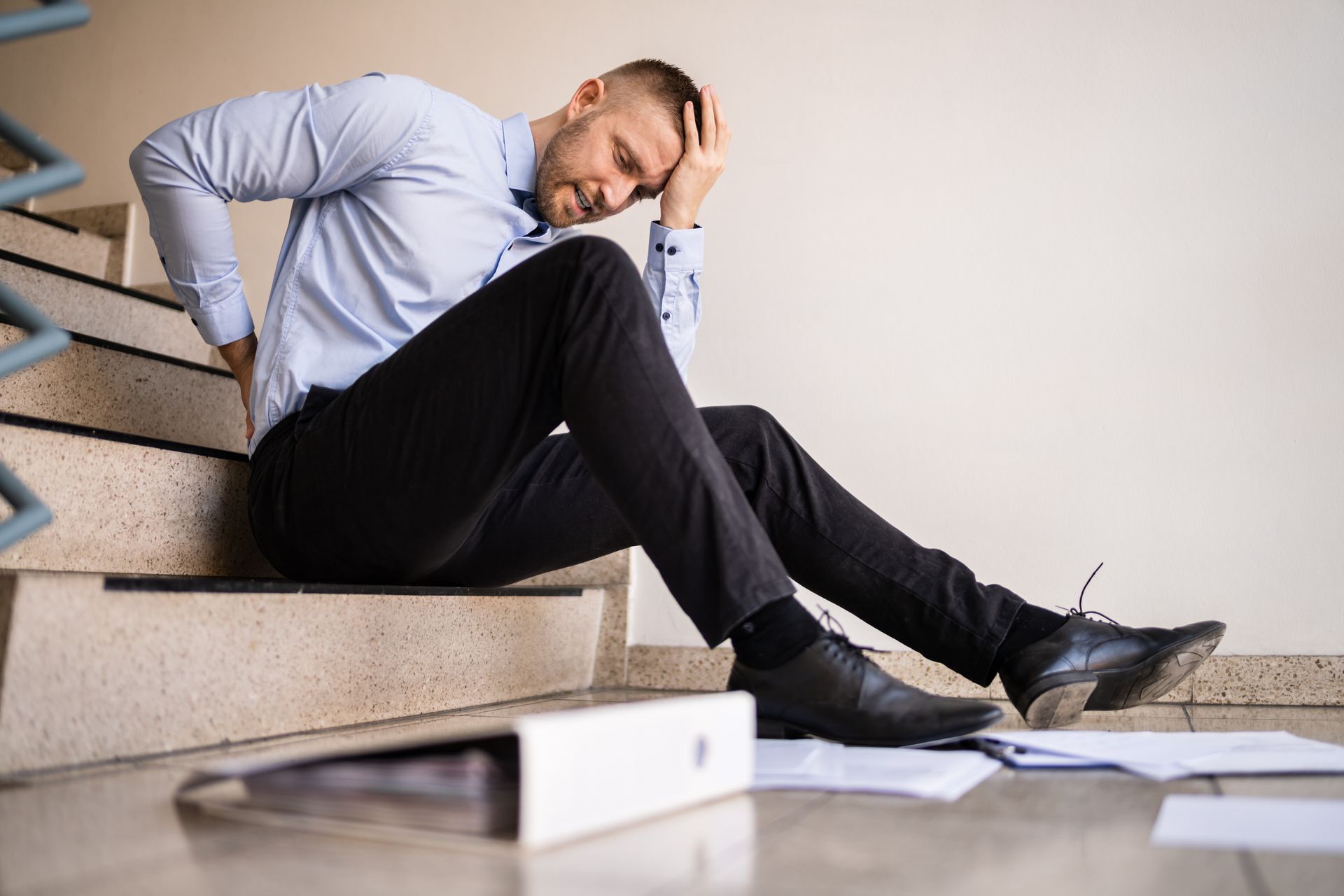 Slip and Fall Image, man on floor with papers scattered around him.