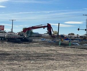 A excavator digs the ground for the foundation and commercial site preparation of a building.