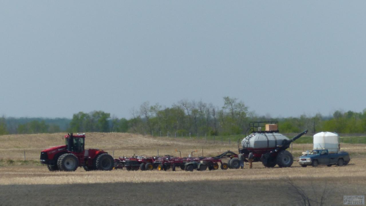 A Case-IH Steiger 4-wheel drive tractor with an air seeder prepares for seeding.