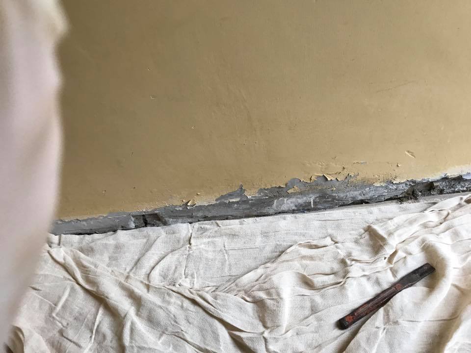 Damp damage to bottom of wall