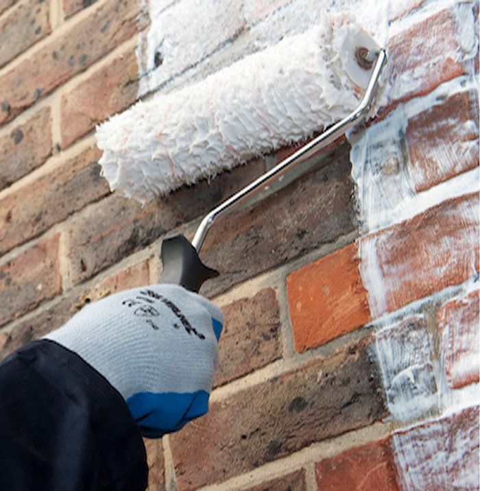 Hand applying stormdry to wall