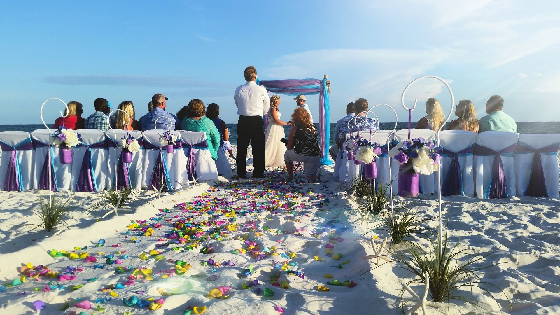 A bride and groom are getting married on the beach.