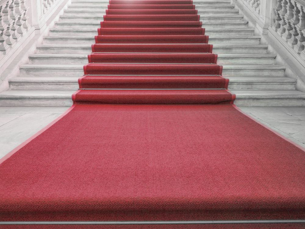 A red carpet is leading up a set of stairs.