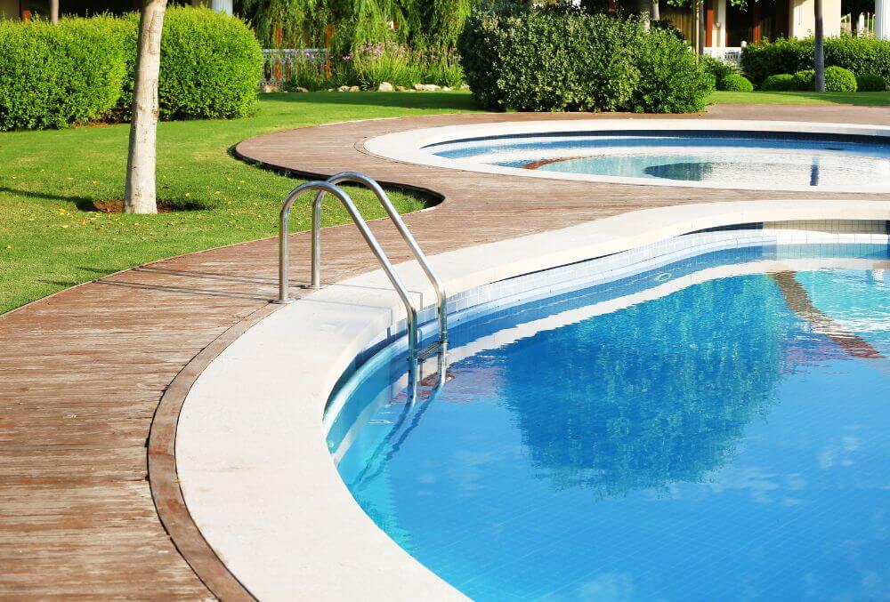 Free formed residential pool with white deck