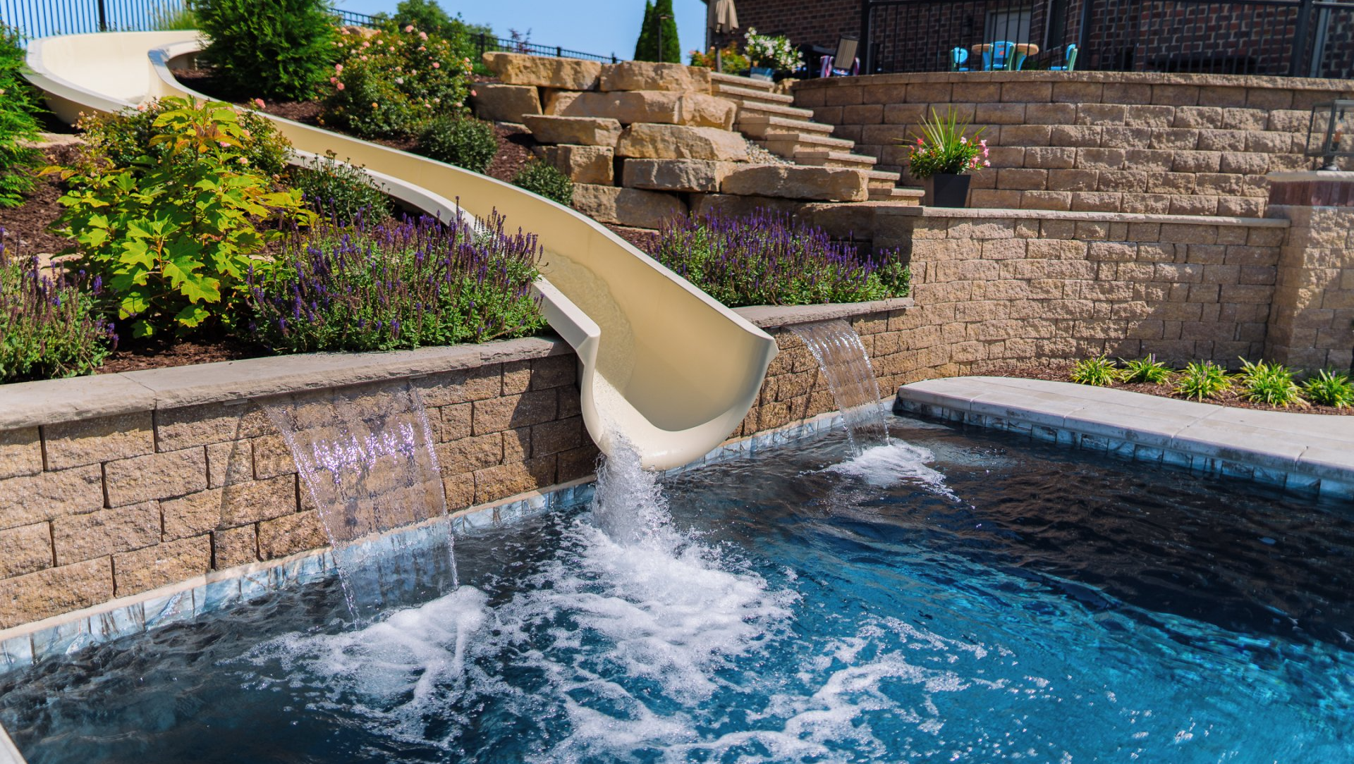 Slide and scuppers water feature in a residential pool