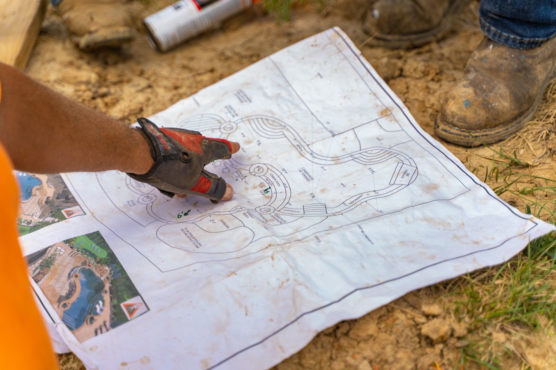 Contractor pointing pool construction blueprint in paper