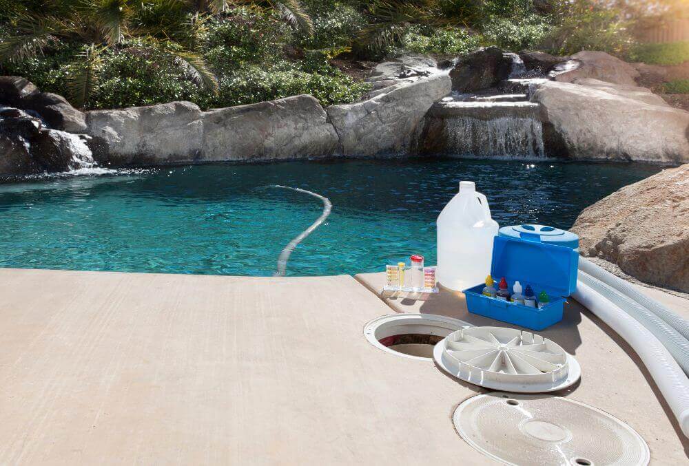 Pool chemicals beside a pool with crystal clear water and nature background