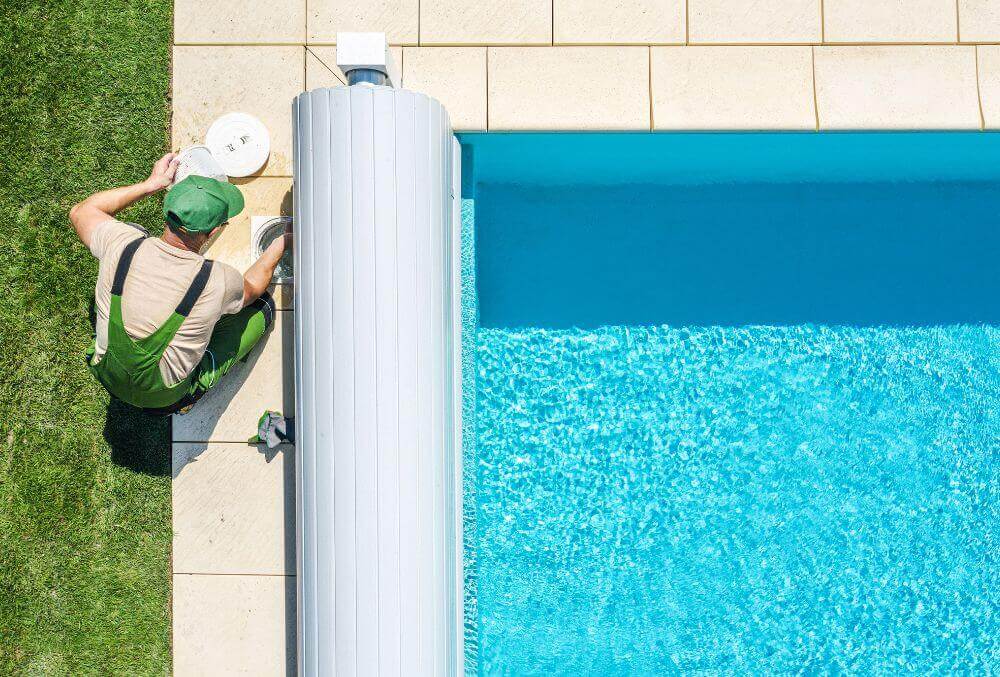 Preparing pool for opening by a man in green suit