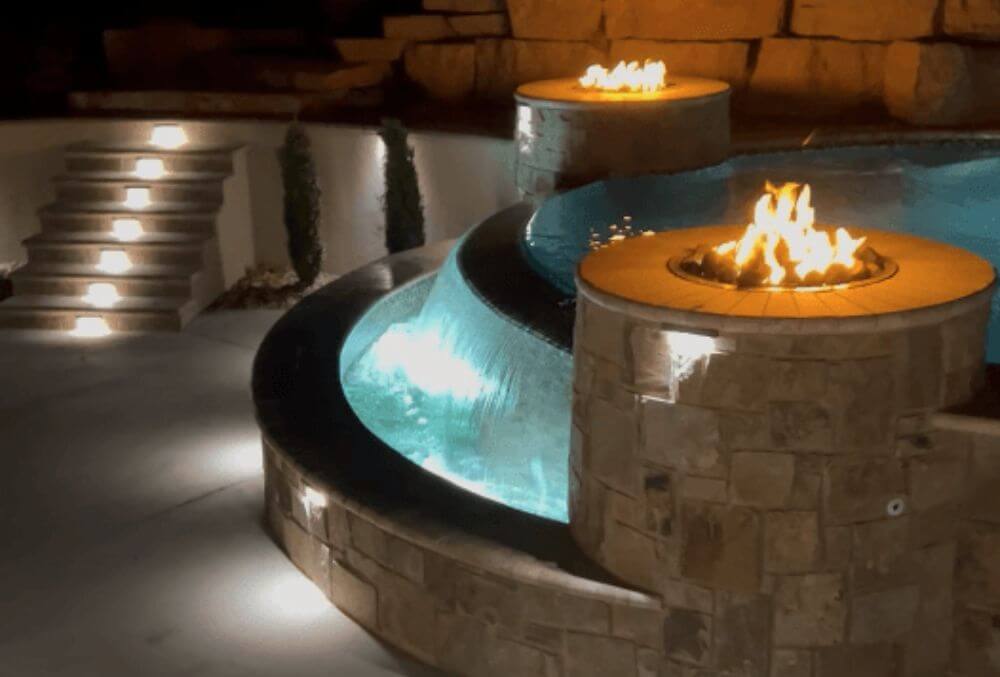 Two fire pits beside a luxury pool