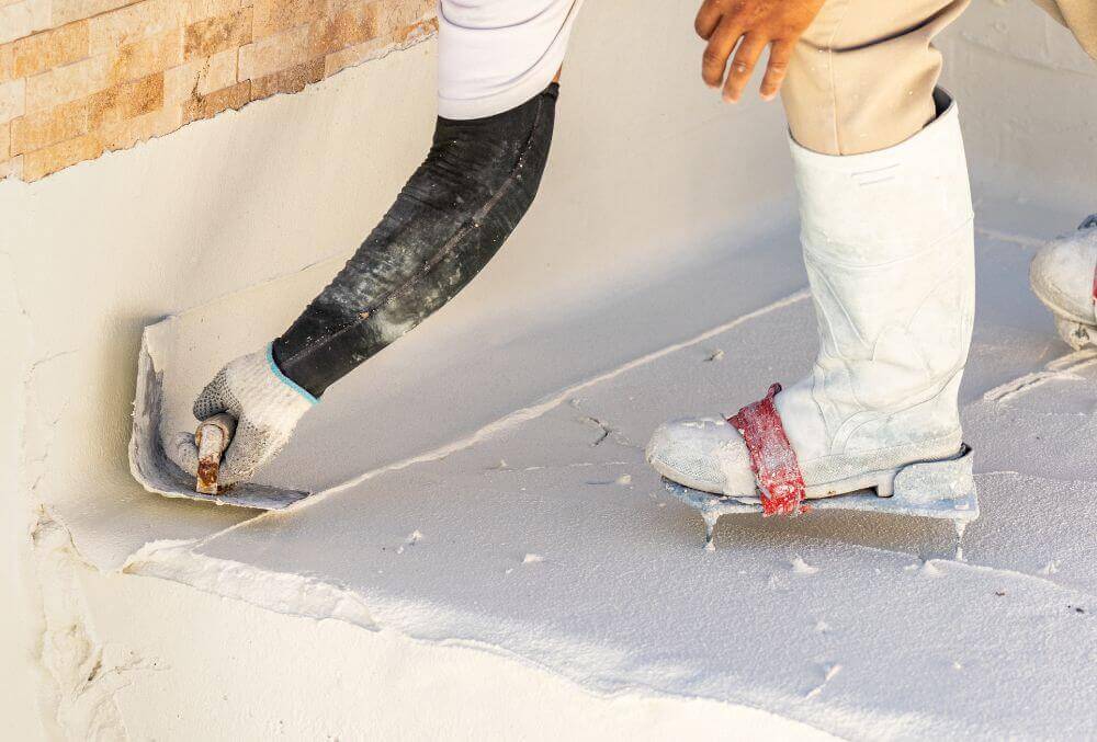 White plaster being applied to a pool for repair
