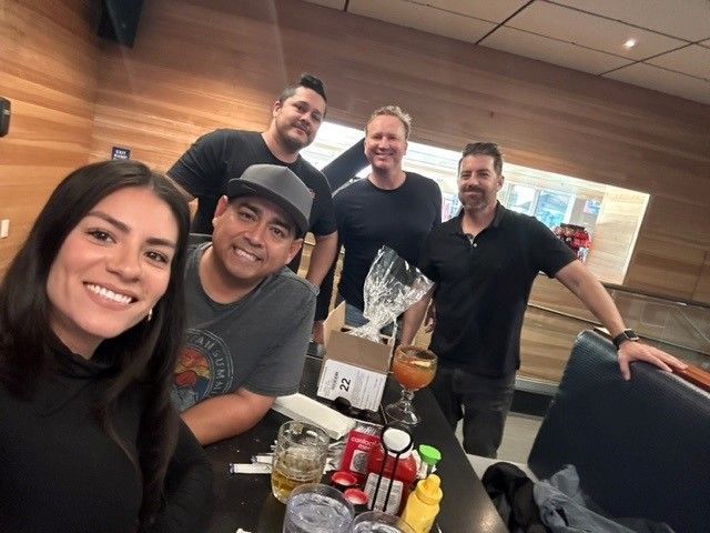 a group of people are posing for a picture in a bowling alley