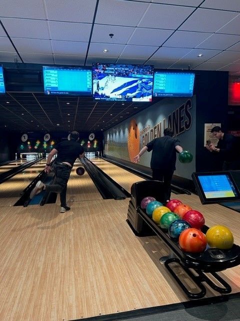 two people are bowling in a bowling alley