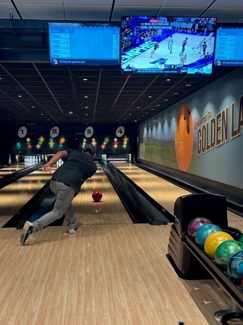 a man is bowling in a bowling alley with a sign that says golden lane
