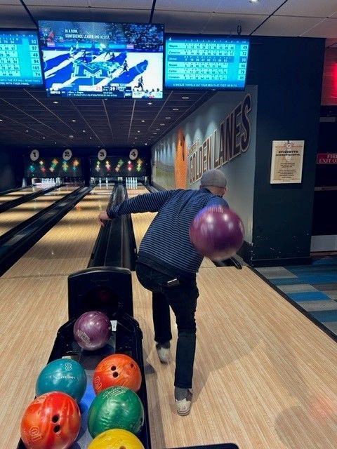 a man is throwing a bowling ball in a bowling alley