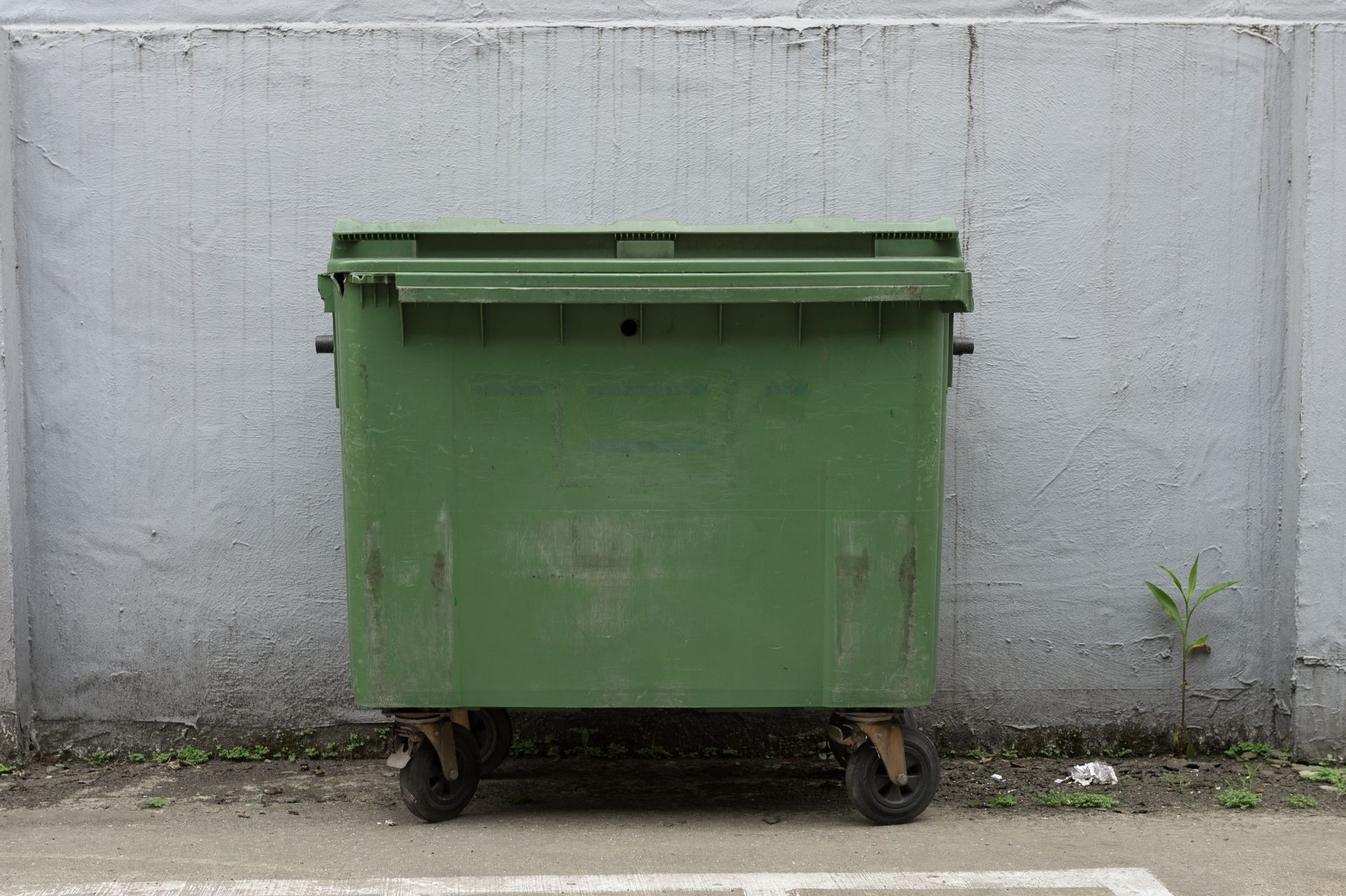 20-yard dumpster rental bin against concrete wall for residential and commercial waste removal.