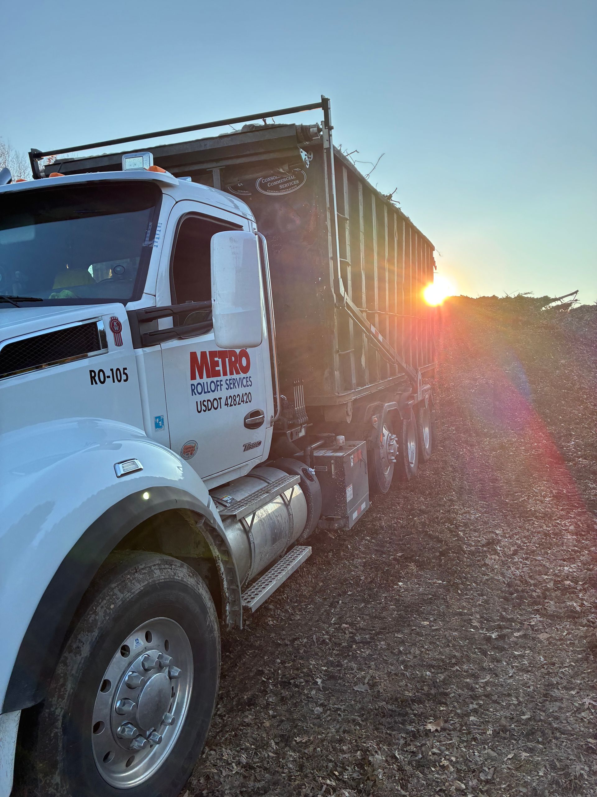 Roll off dumpster with wheels delivered at a construction site.
