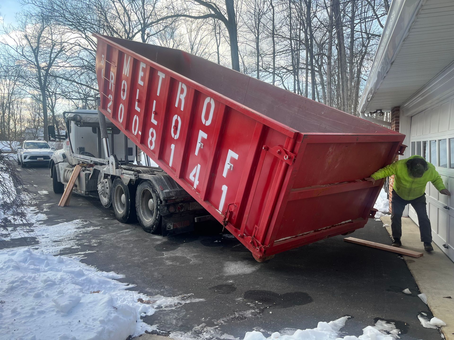 A green dumpster filled with garbage and graffiti on it
