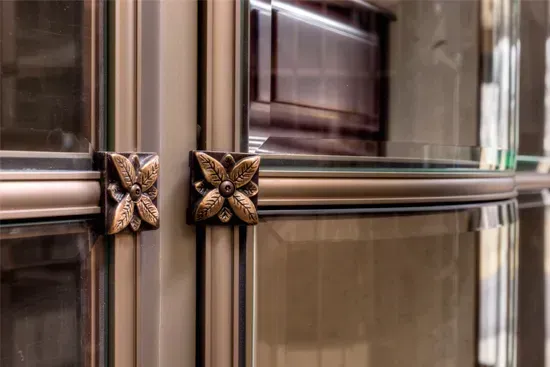 Close-up of ornate bronze butterfly handles on mirrored cabinet doors